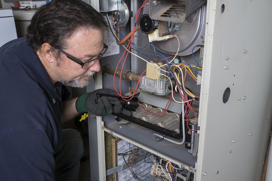 HVAC contractor repairing a furnace